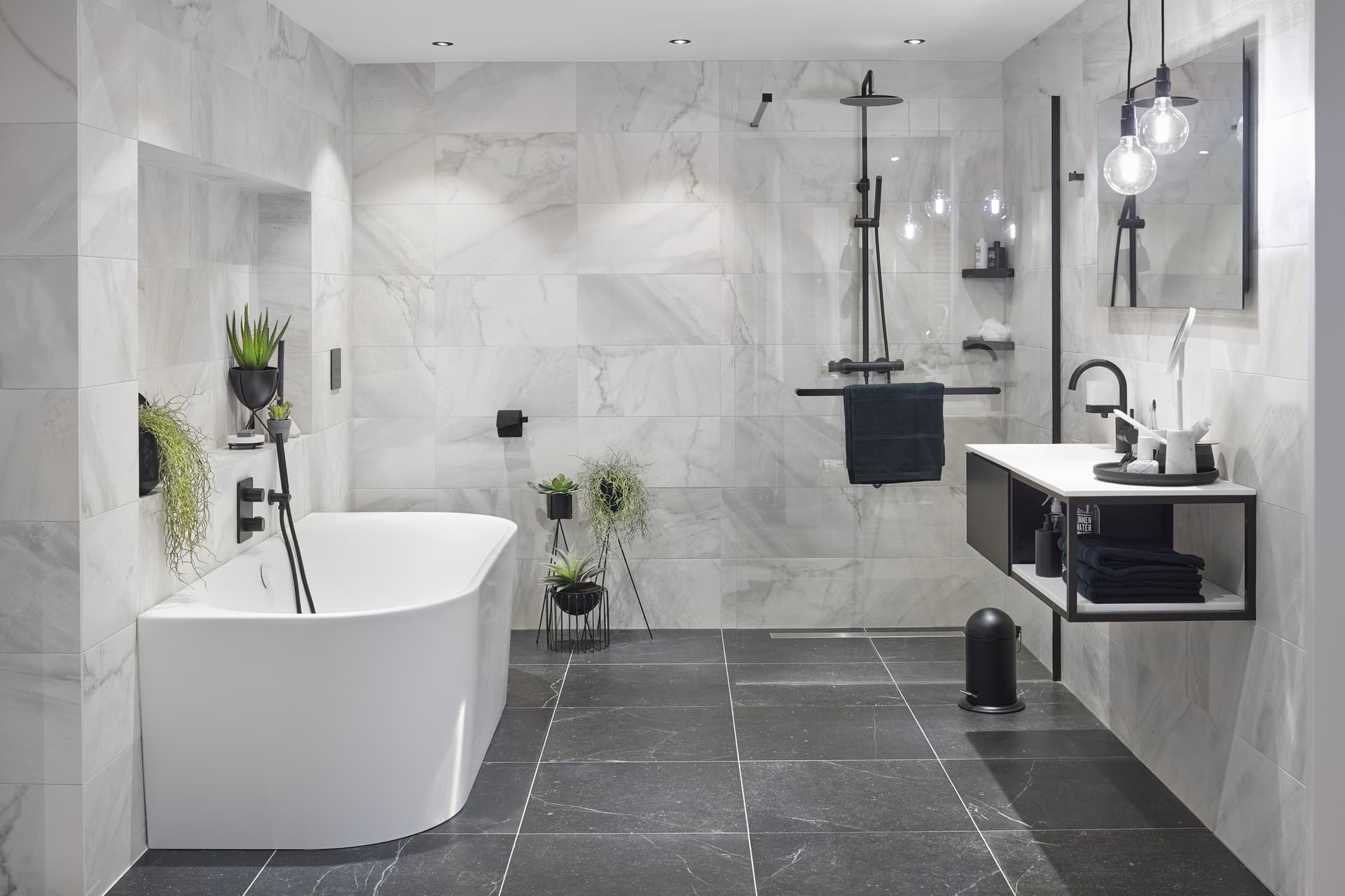 Grijze badkamer met wit bad en een glazen douchewand