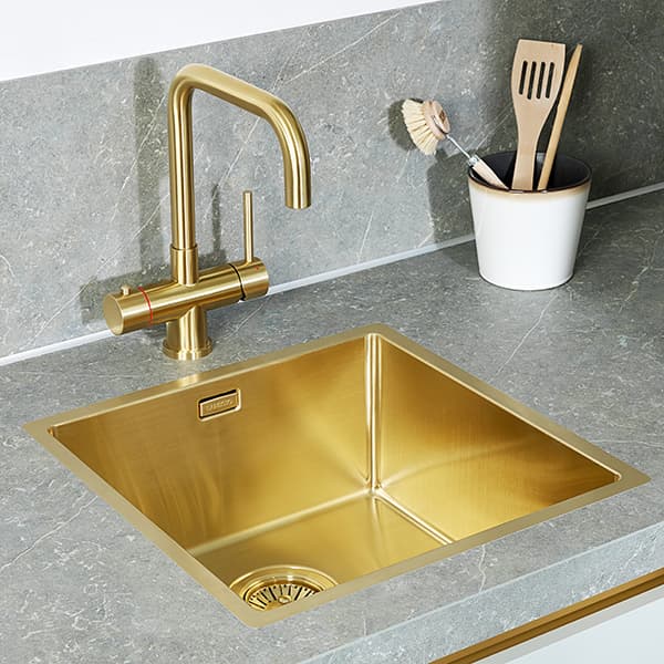 Goudkleurige keukenkraan en spoelbak