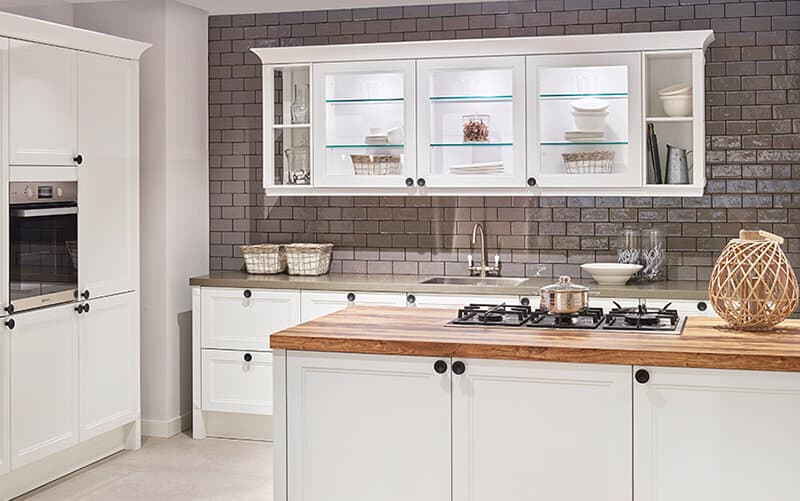 Witte landelijke eilandkeuken met kaderdeuren en houten werkblad