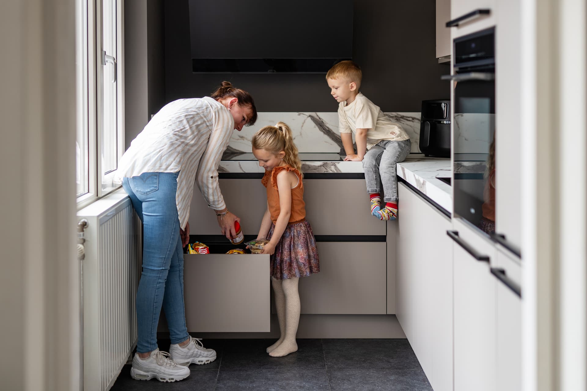Gezin met kinderen in de keuken